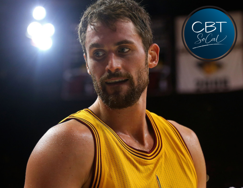 Kevin Love stands on a basketball court and looks to his side